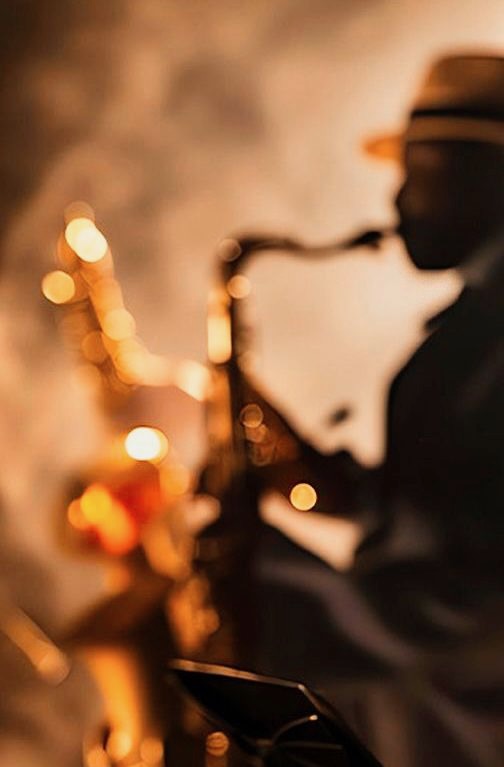Saxophonist playing in warm stage light